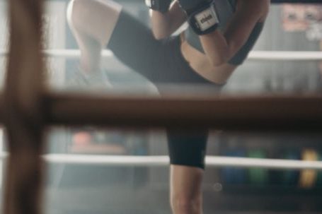 Calorie-blasting Kickboxing - Woman in Black Shirt and Black Shorts Carrying Black Leather Shoulder Bag
