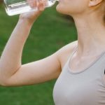 Energize. - Woman in Activewear drinking a Bottle of Water