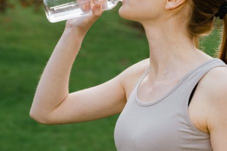 Energize. - Woman in Activewear drinking a Bottle of Water