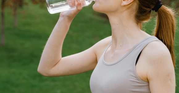 Energize. - Woman in Activewear drinking a Bottle of Water