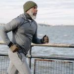 Cardio Fitness - Serious black man running on embankment