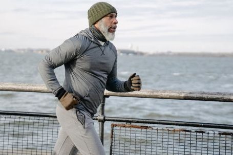 Cardio Fitness - Serious black man running on embankment