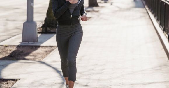Cardio Workouts - Full body of active young ethnic female millennial with dark curly hair in sportswear running on city street during morning workout on sunny day