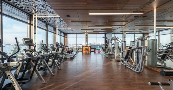 Cardio Workouts - Interior of modern spacious fitness club with various sports machines and equipment placed on parquet floor near panoramic windows