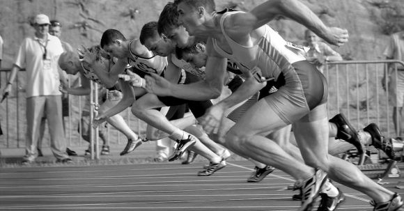 Start Here - Athletes Running on Track and Field Oval in Grayscale Photography