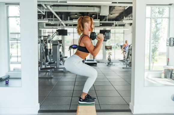 Cardio Exercises - woman wearing black sports bra and white legging lifting dummbells