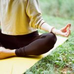 Yoga - woman in brown long sleeve shirt and black pants sitting on white textile