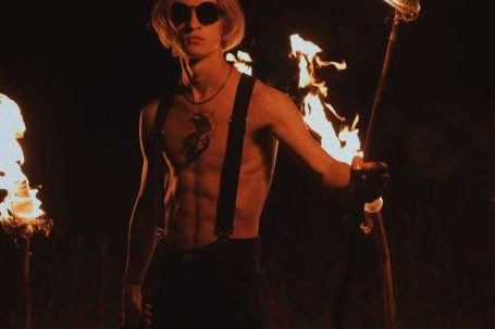 Fit Domination - Blond Man with Bare Torso and Torches at Night