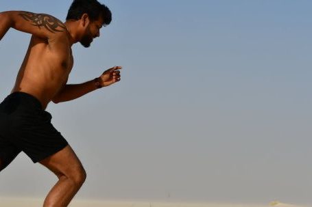 Cardio Integration - Strong shirtless sportsman jogging on bright day