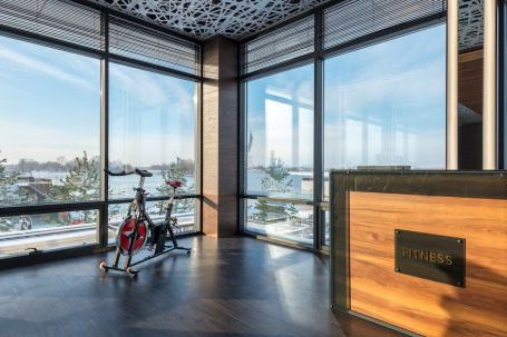 Pilates + Cardio. - Bike machine placed near panoramic windows of contemporary gym