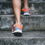 Fitness Exercises - person wearing orange and gray Nike shoes walking on gray concrete stairs