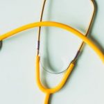 Prevent Imbalances - Top view of yellow medical stethoscope placed on white surface during coronavirus pandemic