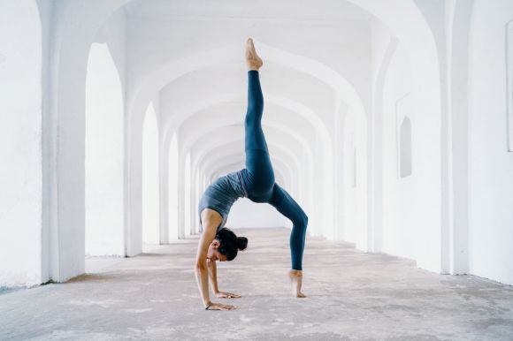 Yoga - woman in blue leggings and black tank top doing yoga