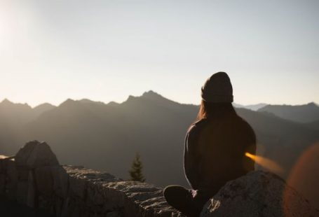 Meditation - person wearing knit cap facing mountain