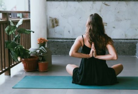 Yoga - woman wearing black shirt sitting on green yoga mat