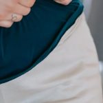 Weight Loss Journey - Crop anonymous plus size female touching belly on blurred background of gym in daytime