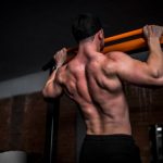 Workouts - topless man in black shorts holding orange bar