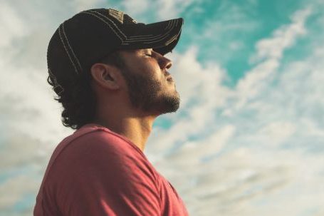 Breathing Benefits - Man Wearing Black Cap With Eyes Closed Under Cloudy Sky