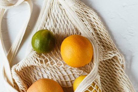 Budget-friendly Nutrition. - Assorted citrus fruits in cotton sack on white surface