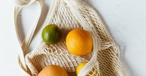 Budget-friendly Nutrition. - Assorted citrus fruits in cotton sack on white surface