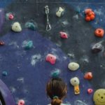 Goal-oriented Workout - Woman preparing for climbing high on wall