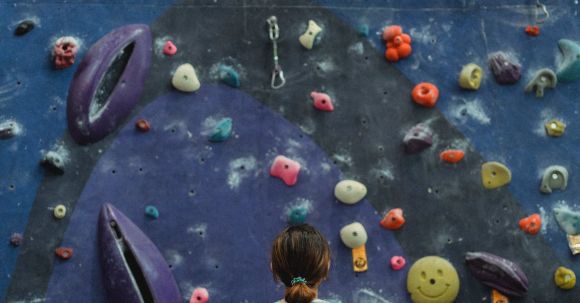 Goal-oriented Workout - Woman preparing for climbing high on wall