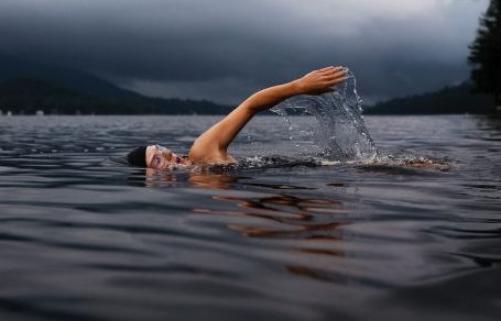 Swimming - man swimming on body of water