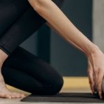 Home Fitness - Woman Unrolling A Yoga Mat