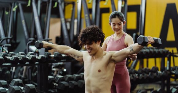 Sports Training - Man Exercising with Dumbbells in Gym