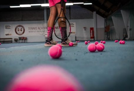 Sports-specific Training - a person standing on a tennis court with a racket