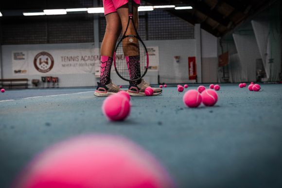 Sports-specific Training - a person standing on a tennis court with a racket